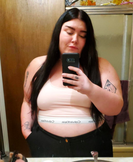 A reviewer's photo featuring the bralette in beige.