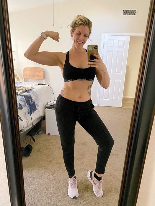 A reviewer showcasing the same sports bra in black, paired with matching black leggings.