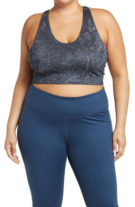 A front view of the model wearing a navy blue floral longline sports bra.