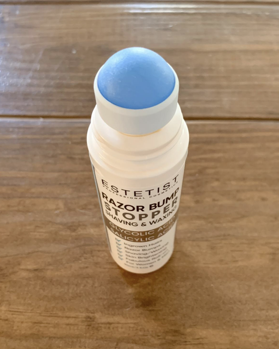 A skin care product bottle labeled 'RAZOR BUMP STOP' containing Salicylic Acid, designed for post-shaving care.