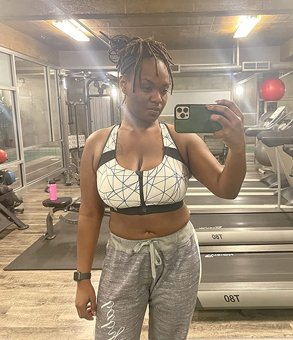 A reviewer wearing the same zip-front sports bra with gray joggers.