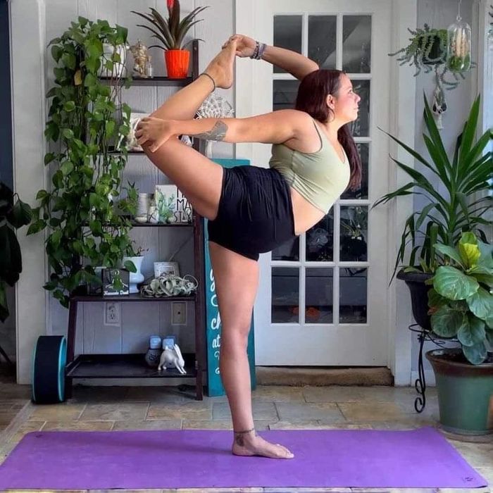 The same reviewer in the green bra performing another standing yoga pose.