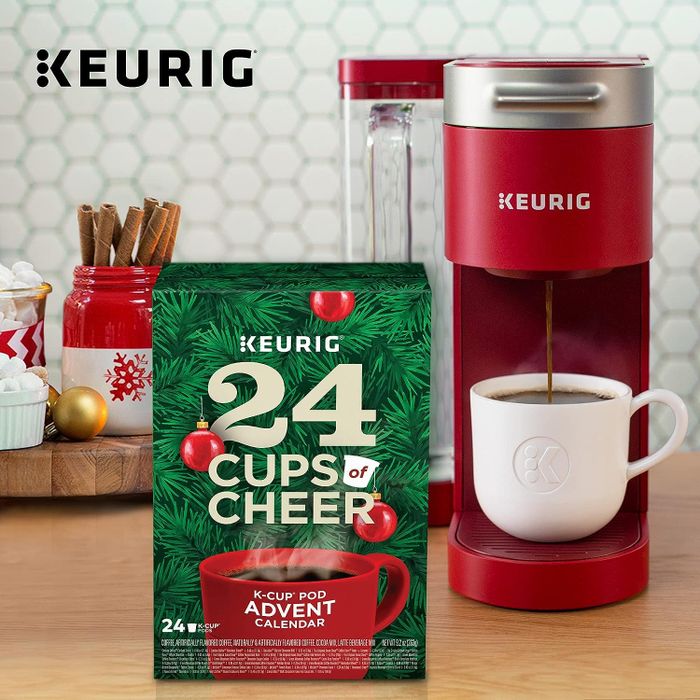 a red single-serve Keurig paired with a 24 Cups of Cheer Advent calendar