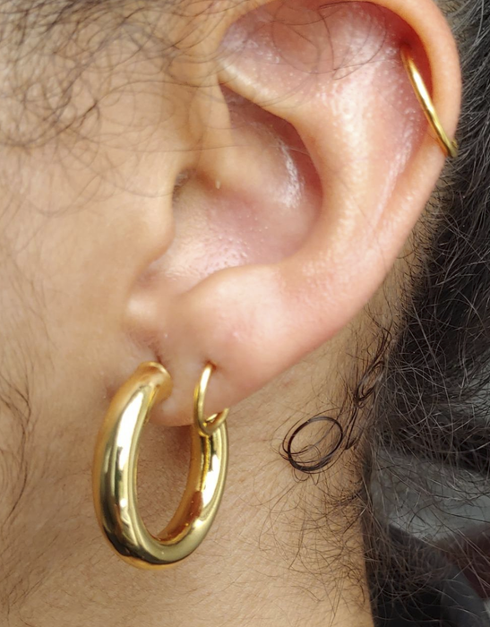 A close-up image of the reviewer, showcasing a delicate gold hoop earring.