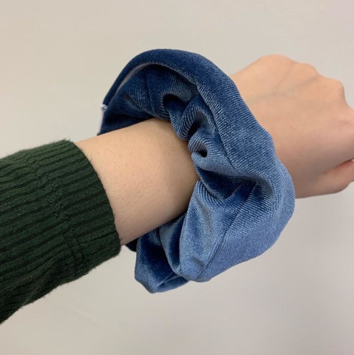 A reviewer’s photo of the scrunchie in navy blue, worn around their wrist.