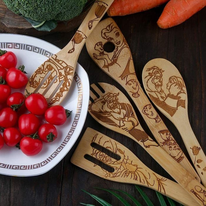 The five utensil pieces, each etched with characters from Beauty and the Beast