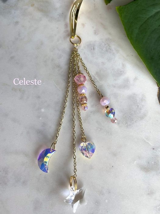 The crystal moon, heart, and star charms featured on a gold chain.