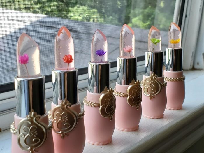 A reviewer’s photo of six jelly lipsticks with a soft pink base.