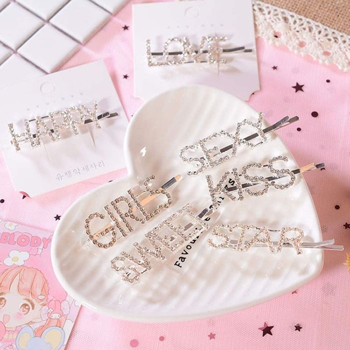 Rhinestone-encrusted hair clips featuring a variety of words such as girls, sweet, kiss, star, sexy, love, and happy.