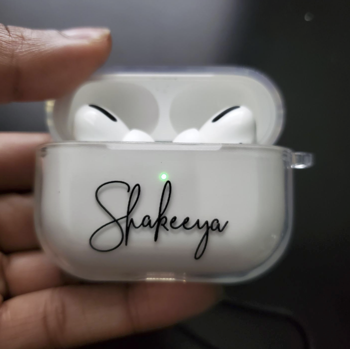 A reviewer's white AirPods case with the name 
