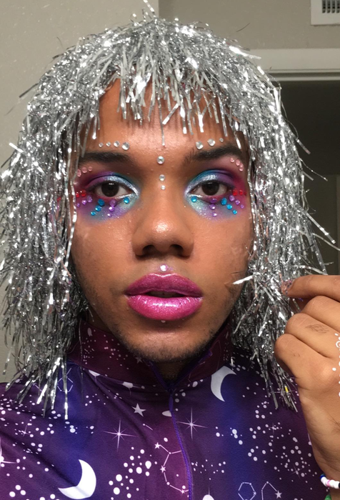 A reviewer wearing colorful gems under their eyes in various shades