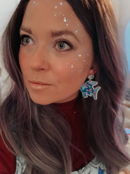 A reviewer showcasing the glitter on their face in white