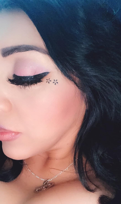 A reviewer applying the flower stamp around the outer corner of their eye.