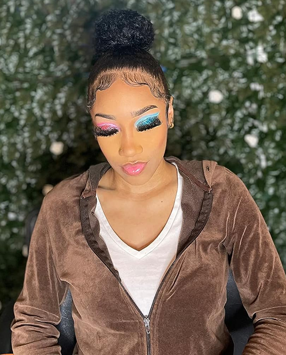 A reviewer wearing the eyeliner in vibrant pink and blue