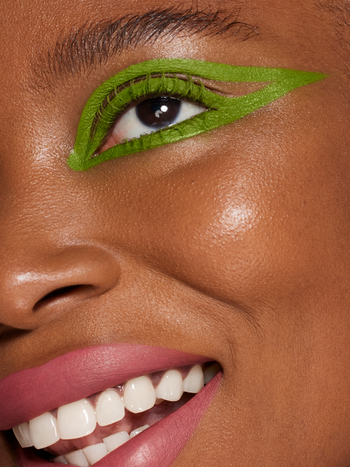 A model wearing green graphic eyeliner applied with the eye paint