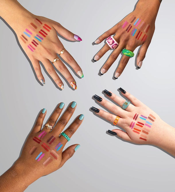 Four models of different skin tones showcasing the lipliners swatched on their hands.