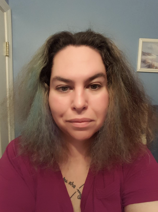A reviewer showing their frizzy hair before using the mask.