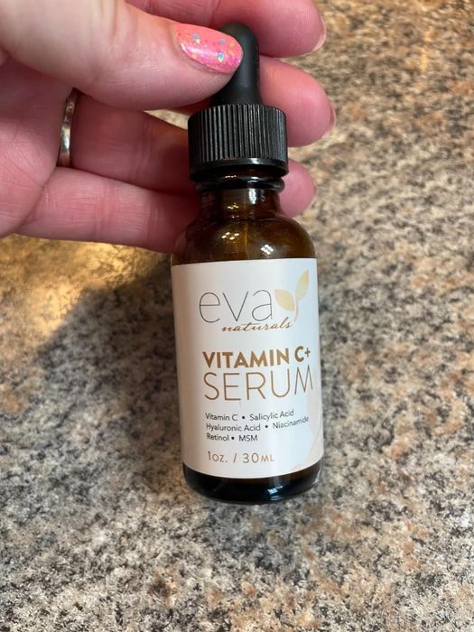 Image of a reviewer holding a bottle of serum