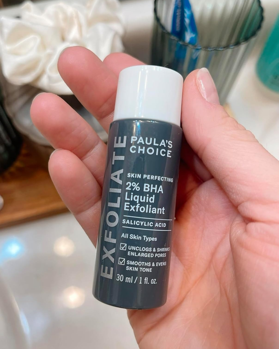 Image of a reviewer holding a small bottle of exfoliant