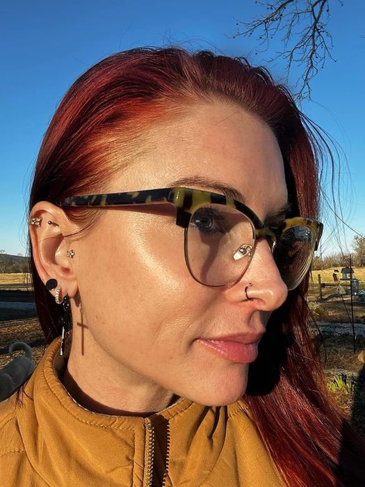 Reviewer applying the glow-enhancing sunscreen while basking in direct sunlight, showing off its glowing effect