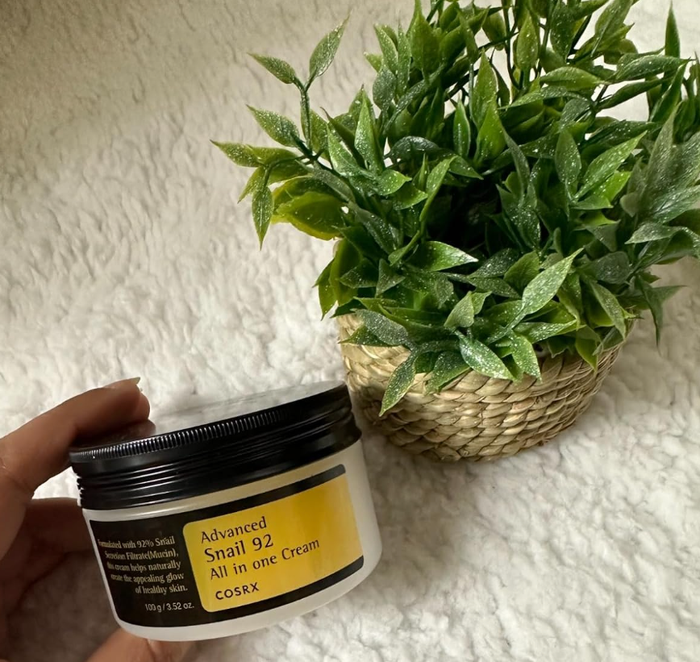 reviewer holding a jar of the moisturizer