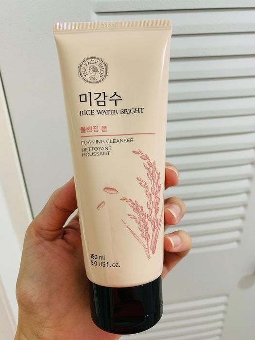 A reviewer holding the cleanser in their hand.