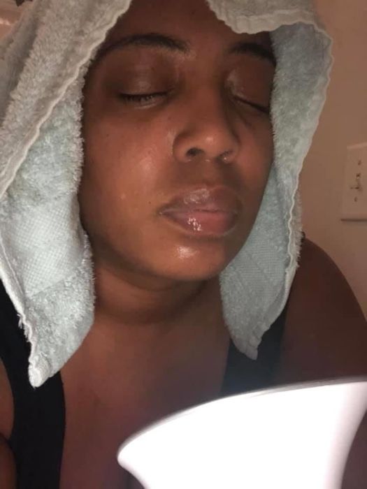 A reviewer using the facial steamer with a towel draped over their head.