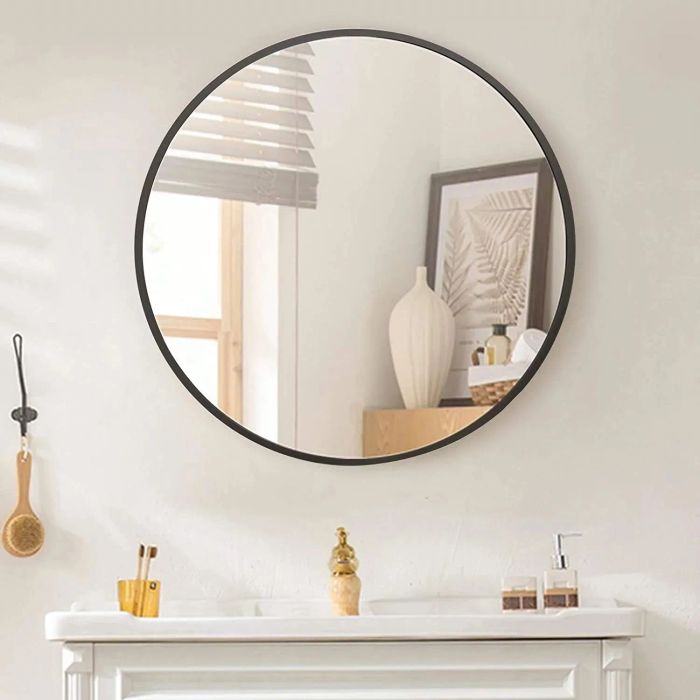 a round wall mirror featuring a sleek black frame