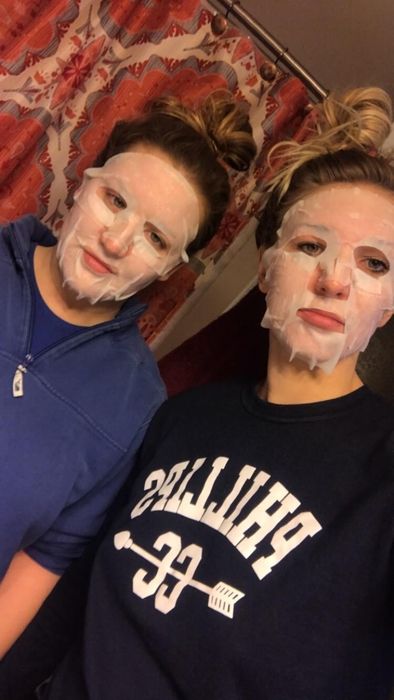 Two reviewers wearing the sheet masks on their faces