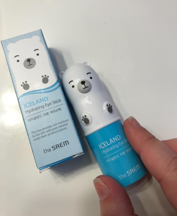 A reviewer holding the eye stick tube next to its original box