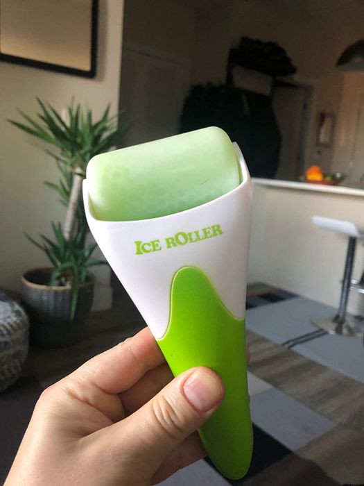 Another reviewer holding the green ice roller, ready to use.