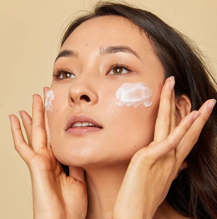 model applying facial cleanser