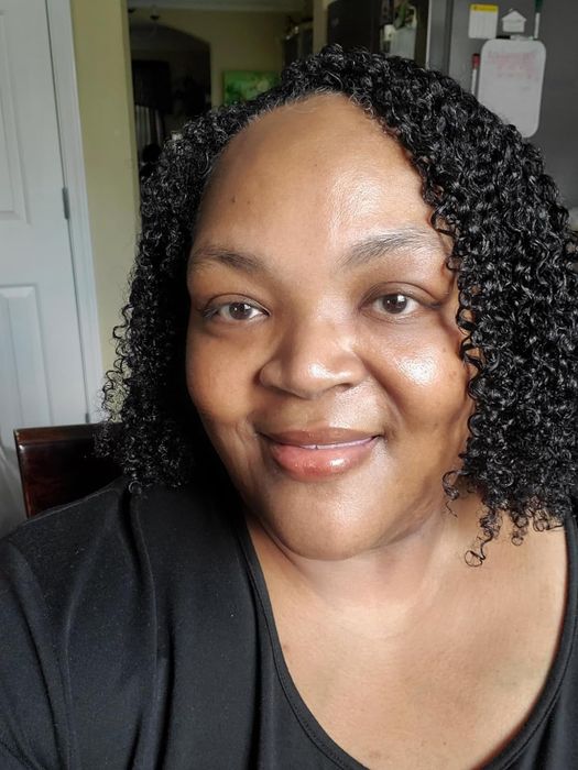 The reviewer beaming with glowing skin after using the ampoule.