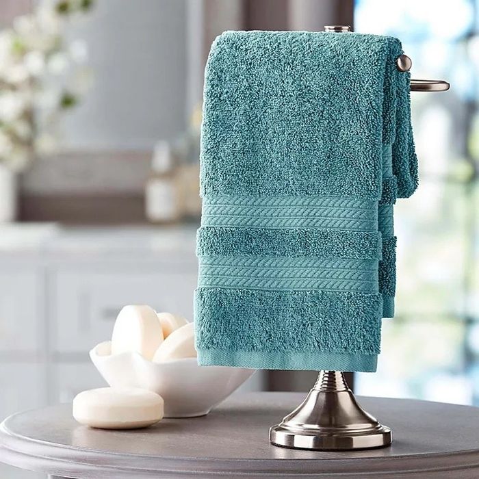 a blue hand towel placed beside a couple of soap bars