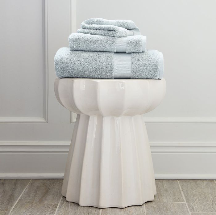 A neat stack of light blue plush towels, perfect for adding a touch of luxury to any bathroom.