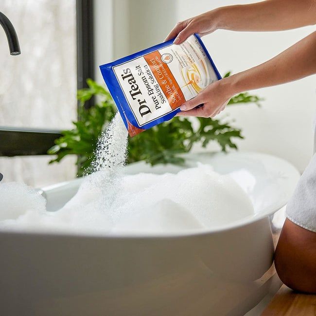 A model gracefully pouring bath salts into a tub