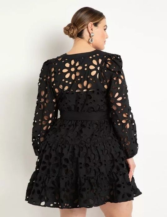 The model is shown from the back, showcasing the eyelet detailing of the black dress.
