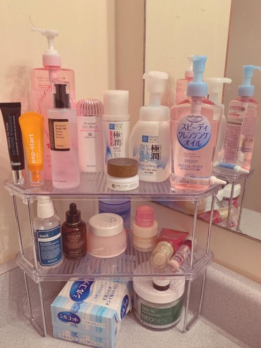reviewer's skincare products organized on a three-tier shelf system