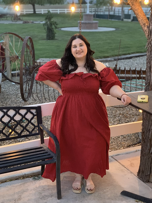 A reviewer wearing a red midi dress.