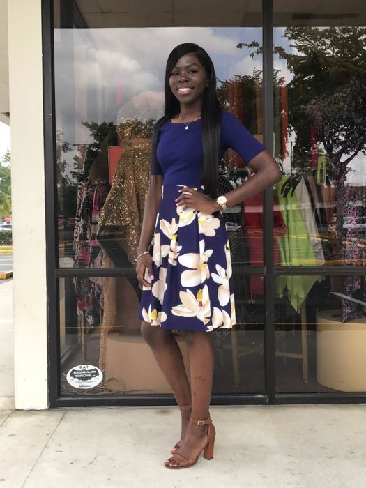 A reviewer styles a midi dress with three-quarter sleeves, adorned with a floral pattern on the skirt.