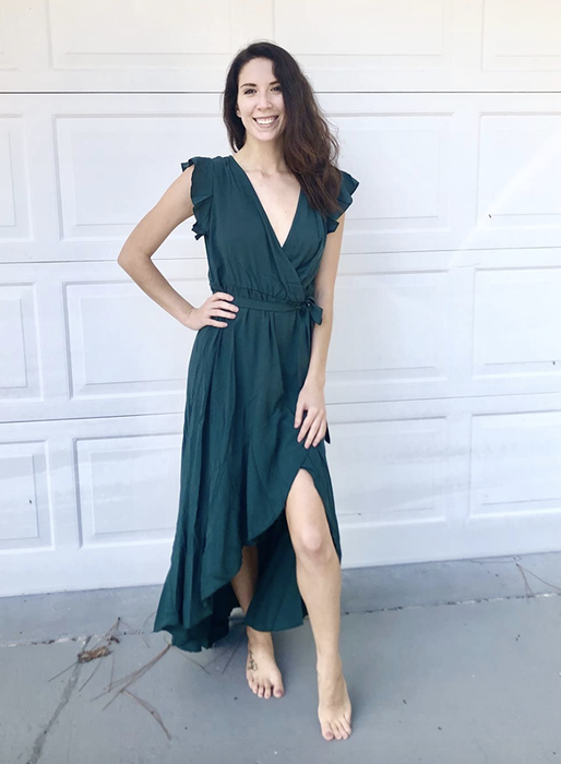 A reviewer is seen wearing a chic green dress.