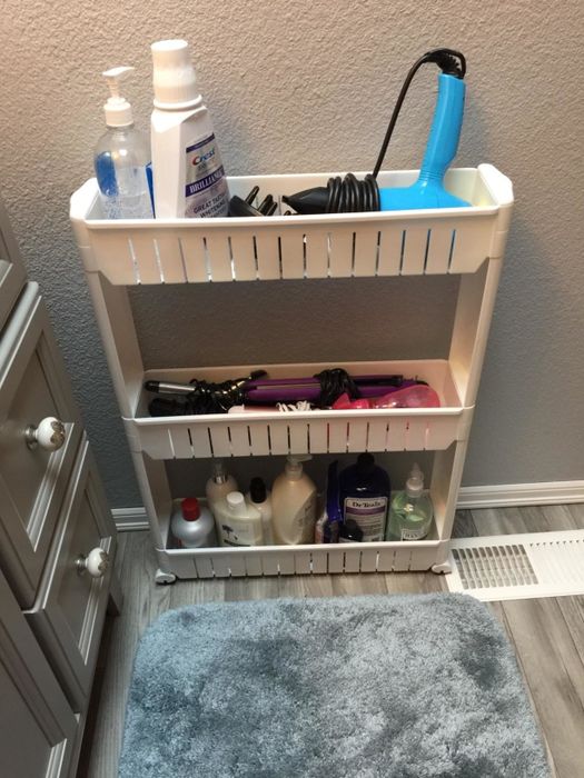 reviewer's white storage tower filled with essential bathroom items