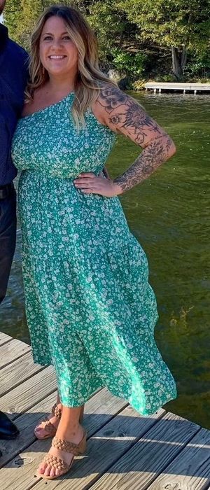 A reviewer showcasing the dress in a lovely green and white print.