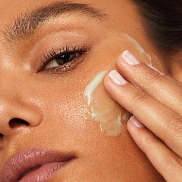 A model applying retinol to their skin
