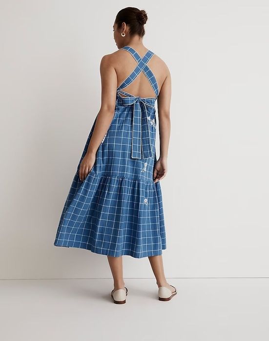 The model showcases the criss-cross and bow details at the back of the dress.