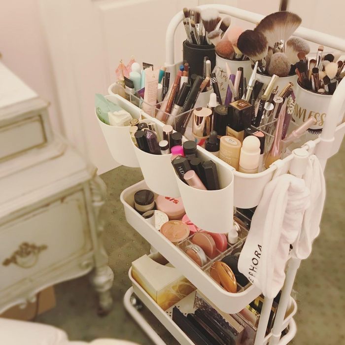 reviewer's extensive makeup collection neatly organized on a rolling cart