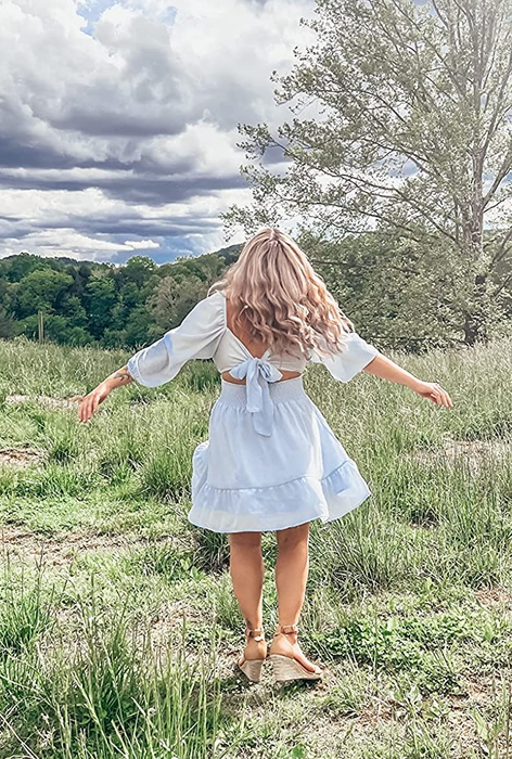A reviewer shows off the tie feature at the back of the dress.