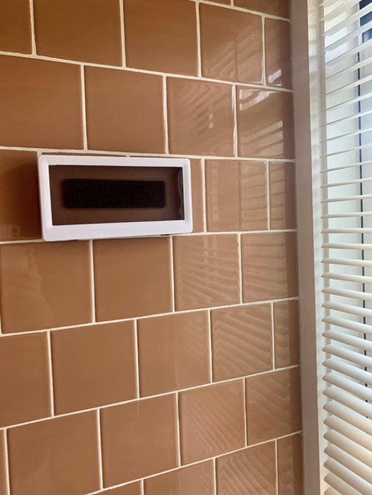 A reviewer's tiled shower featuring the shower phone holder attached for a more convenient experience.