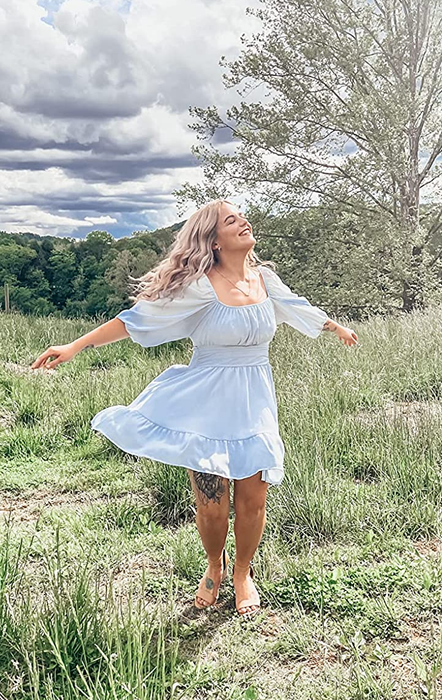 A reviewer is pictured wearing the dress in a beautiful shade of blue.