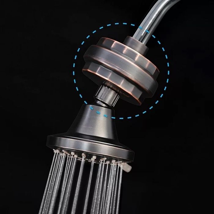 A brass shower filter attached to a showerhead, designed to enhance water quality.